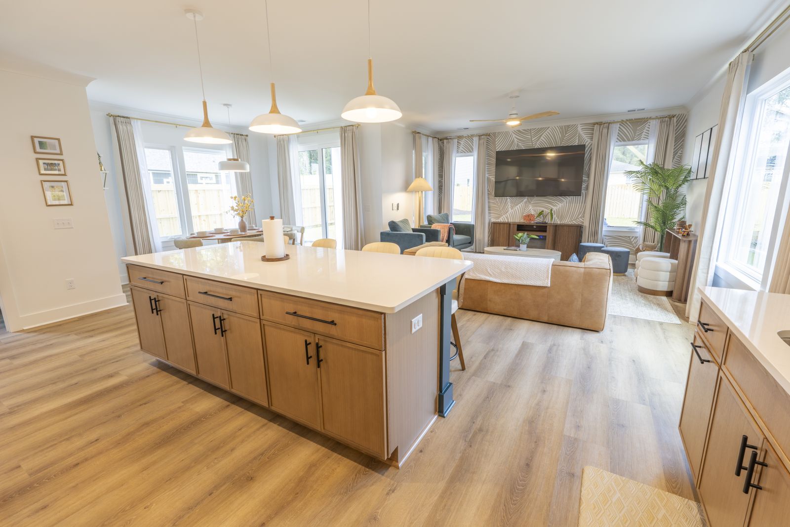 Open kitchen with a long wood island and the living room beyond